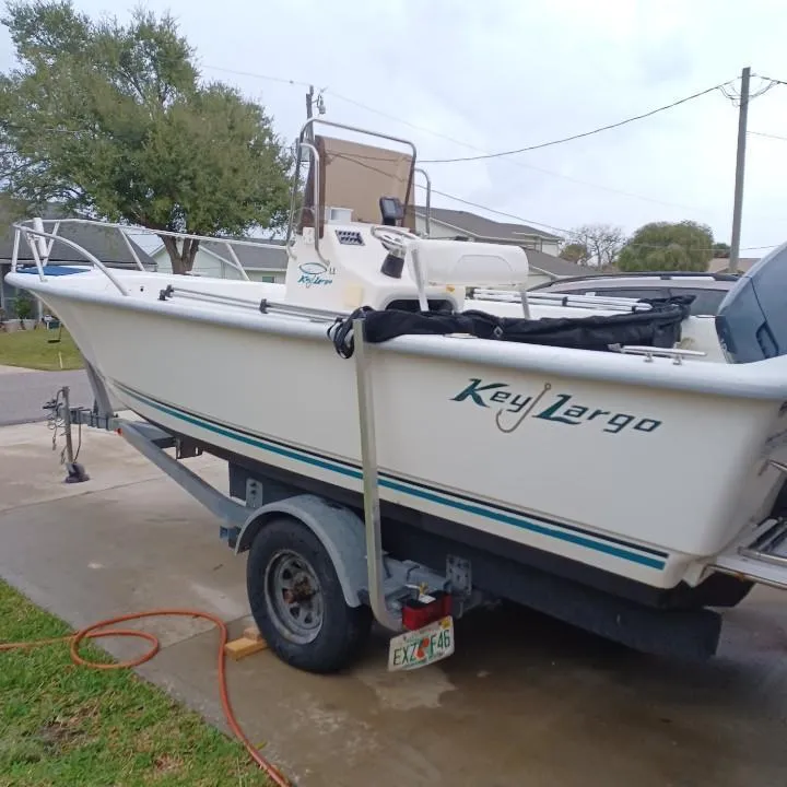 Slide: The Image of 2011 Key Largo 20' Center Console boat on trailer in residential driveway. - 2
