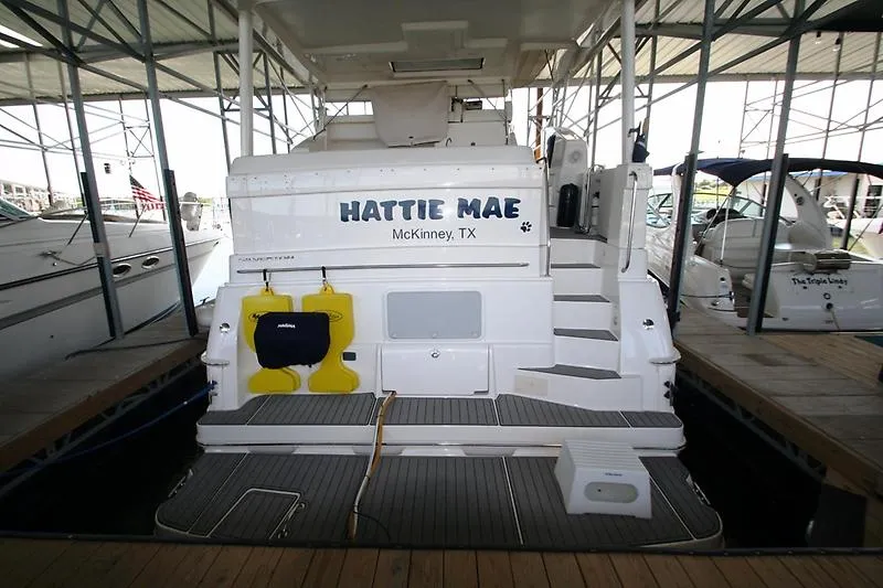 Slide: The Image of 1999 Silverton 392 Motor Yacht docked, rear view with "Hattie Mae" name visible. - 2