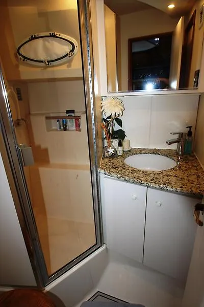 Slide: The Image of 1999 Silverton 392 Motor Yacht bathroom with granite countertop and enclosed shower. - 26