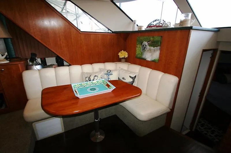 Slide: The Image of 1999 Silverton 392 Motor Yacht interior with white leather seating and wooden table. - 28