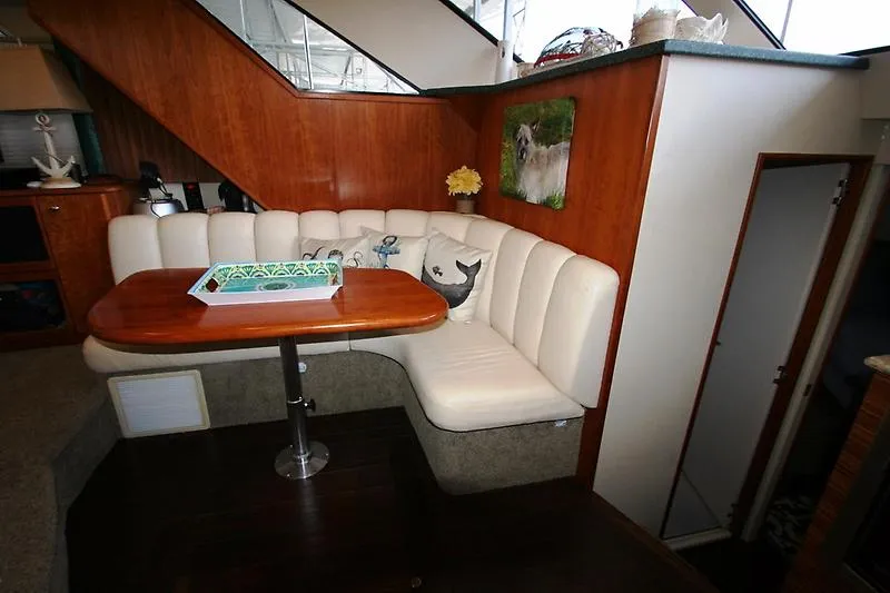 Slide: The Image of 1999 Silverton 392 Motor Yacht interior with cozy dining area and white leather seating. - 29