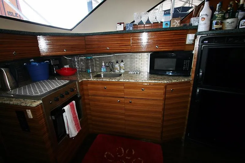 Slide: The Image of 1999 Silverton 392 Motor Yacht kitchen with wooden cabinets, granite countertops, and modern appliances. - 31