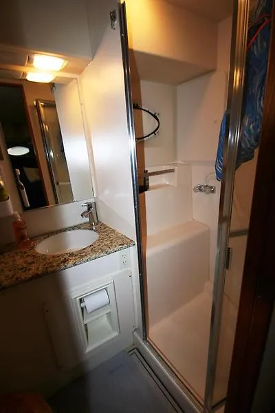 Slide: The Image of 1999 Silverton 392 Motor Yacht bathroom with shower, sink, and granite countertop. - 42