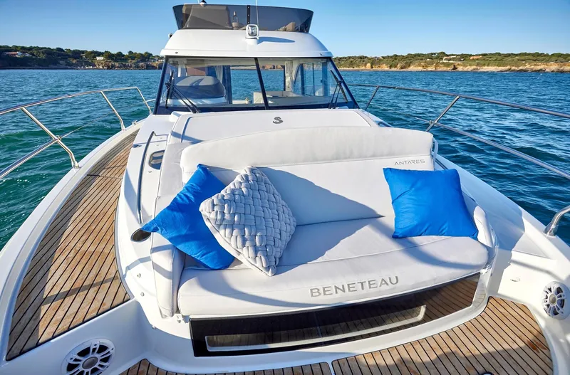 Slide: The Image of 2024 Beneteau Antares 12 yacht with cushioned deck seating and ocean view. - 9