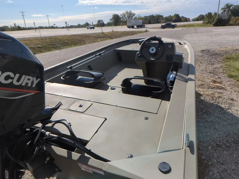 Slide: The Image of 2024 Tracker Grizzly 1754 SC boat with Mercury engine, parked on a gravel lot. - 11