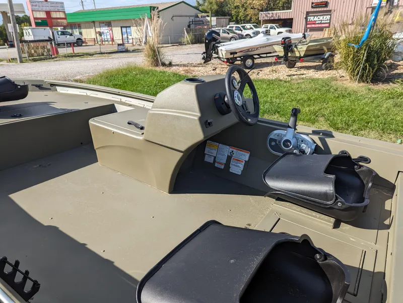 Slide: The Image of 2024 Tracker Grizzly 1754 SC boat interior with steering console and seating. - 12