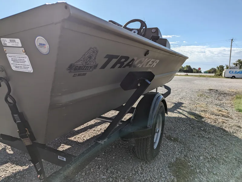 Slide: The Image of 2024 Tracker Grizzly 1754 SC boat on a trailer in a gravel lot. - 6