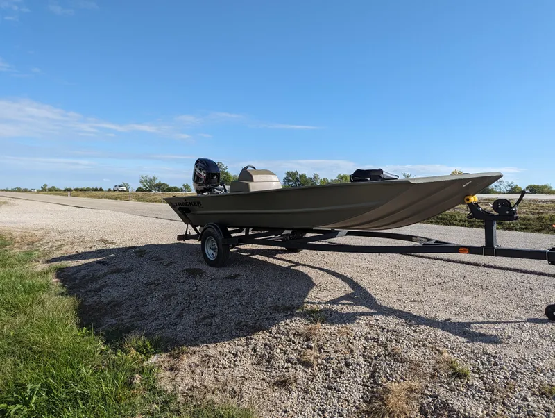 Slide: The Image of 2024 Tracker Grizzly 1754 SC boat on a trailer under a clear blue sky. - 9