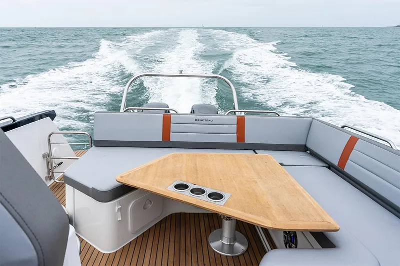 Slide: The Image of Woman preparing food on 2024 Beneteau Flyer 10 boat, with scenic ocean backdrop. - 11