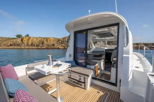 Slide: The Image of 2024 Beneteau Antares 8 V2 yacht with outdoor seating and scenic coastal view. - 4