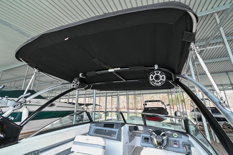 Slide: The Image of 2020 Cobalt CS23 boat interior with black bimini top and modern dashboard. - 12