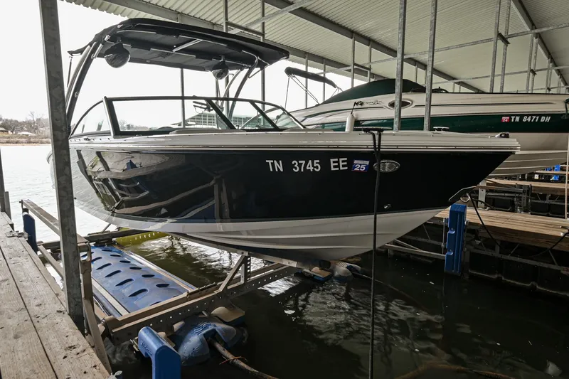 Slide: The Image of 2020 Cobalt CS23 boat docked in a covered marina. - 2