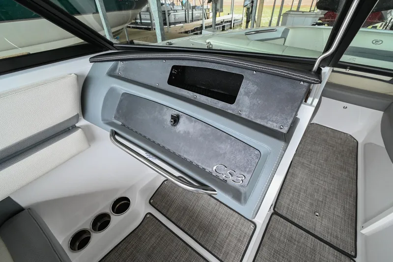Slide: The Image of 2020 Cobalt CS23 boat interior dashboard with storage compartment and cup holders. - 27