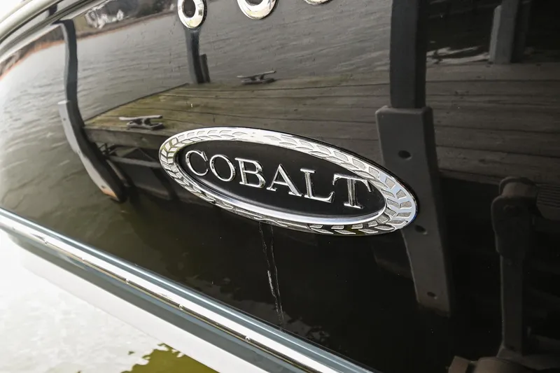 Slide: The Image of 2020 Cobalt CS23 boat logo on black hull near dock. - 5