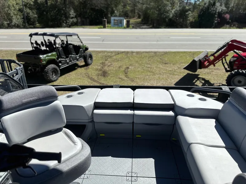 Slide: The Image of Interior of 2024 Sea-Doo SWITCH CRUISE 21FT 230HP with off-road vehicles in background. - 12