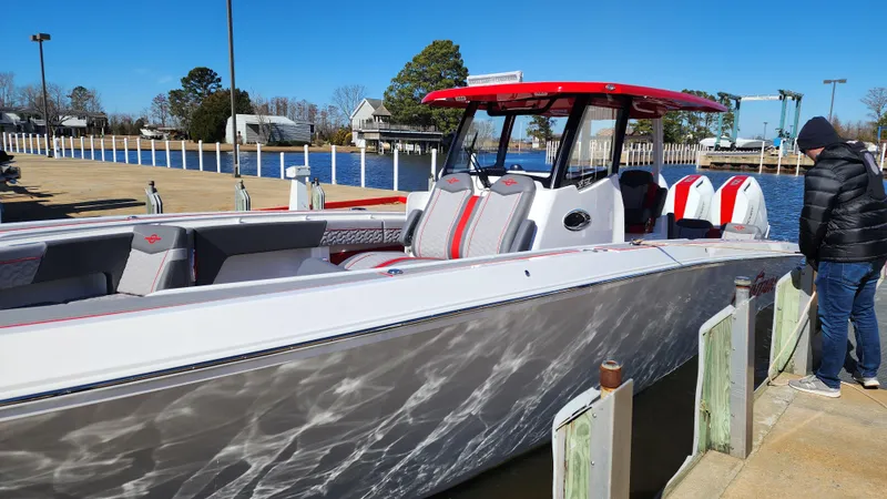 Slide: The Image of 2024 Fountain 38 SC boat docked, featuring sleek design and red accents. - 2