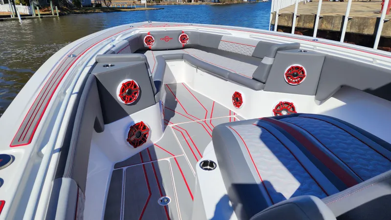 Slide: The Image of 2024 Fountain 38 SC boat interior with red and gray seating and speakers. - 8