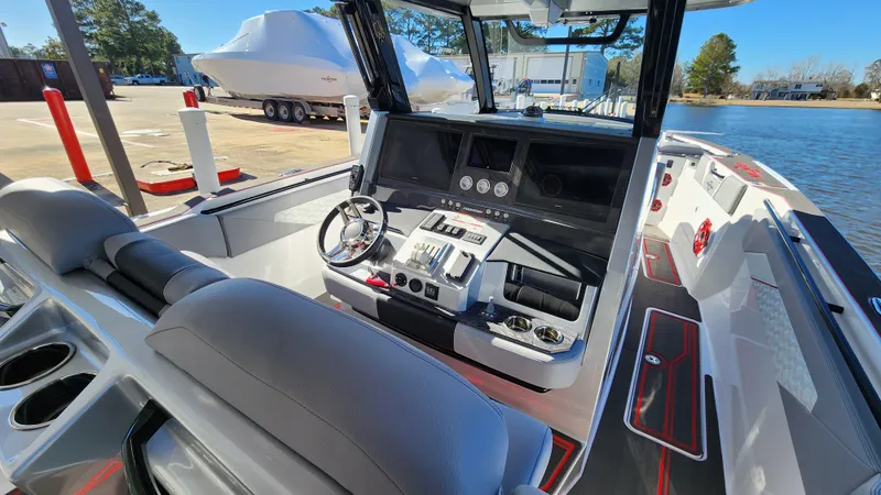 Slide: The Image of 2024 Fountain 38 SCX boat cockpit with modern controls and seating, docked near water. - 10