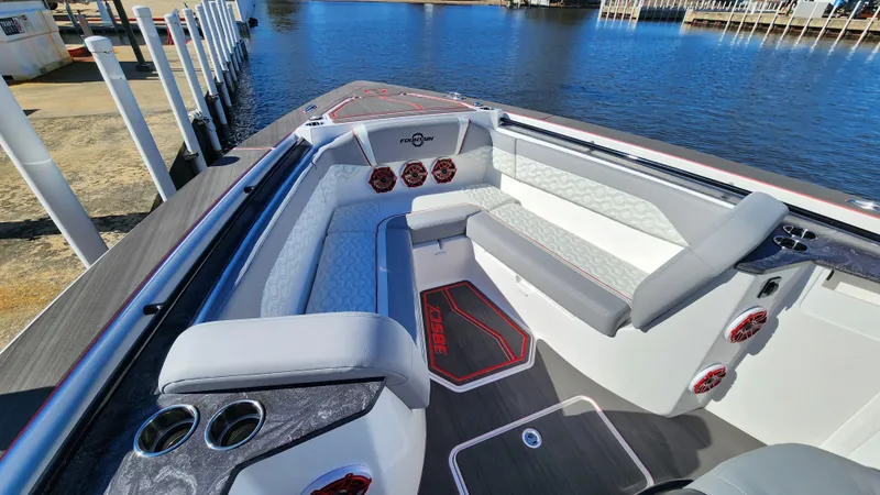 Slide: The Image of 2024 Fountain 38 SCX boat interior with luxurious seating and cup holders by the water. - 20