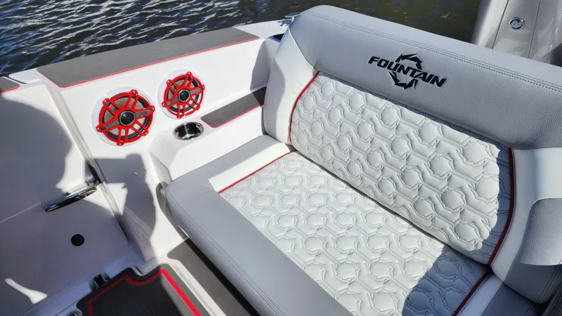 Slide: The Image of 2024 Fountain 38 SCX boat interior with white quilted seats and red speakers. - 6