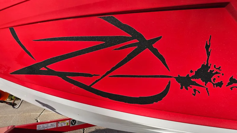 Slide: The Image of Red 2013 Tigé Z1 boat with black graphic design on the side. - 21