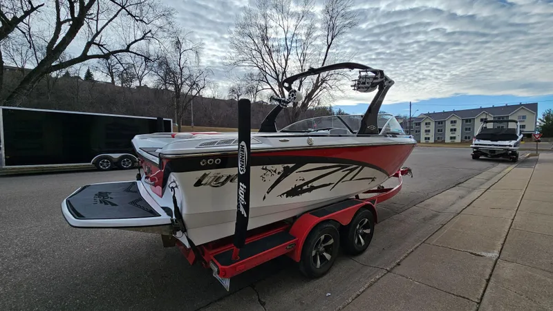 Slide: The Image of 2013 Tigé Z1 boat on a red trailer parked on a street. - 4