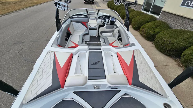 Slide: The Image of 2013 Tigé Z1 boat interior with red and gray seating, steering wheel, and speakers. - 6