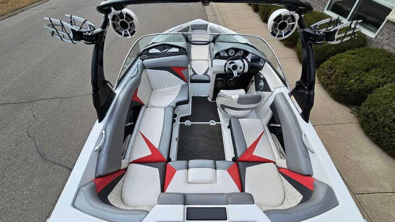 Slide: The Image of 2013 Tigé Z1 boat interior with red and gray seating, steering wheel, and speakers. - 7