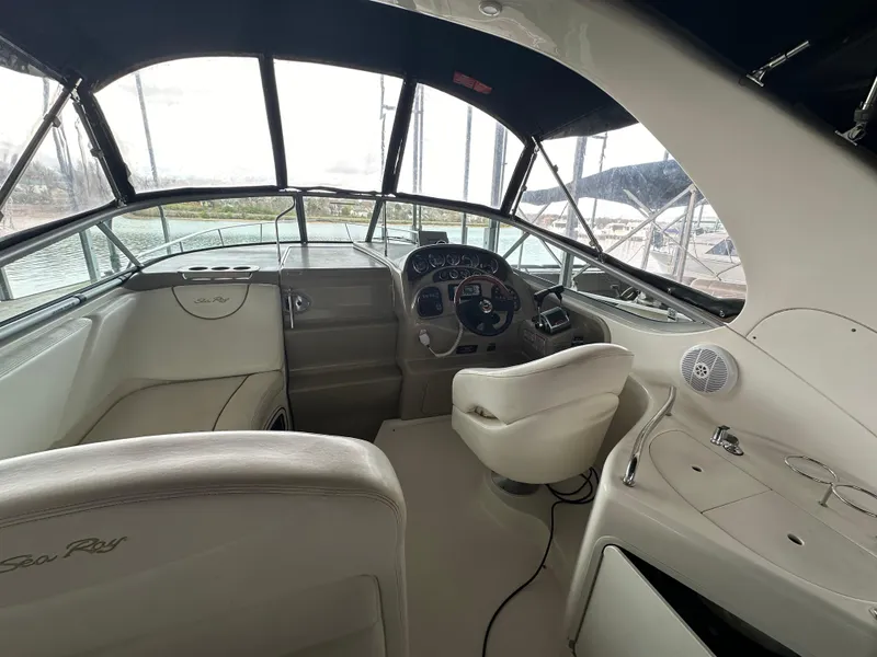 Slide: The Image of 2003 Sea Ray 280 Sundancer boat cockpit with steering wheel and seating. - 10