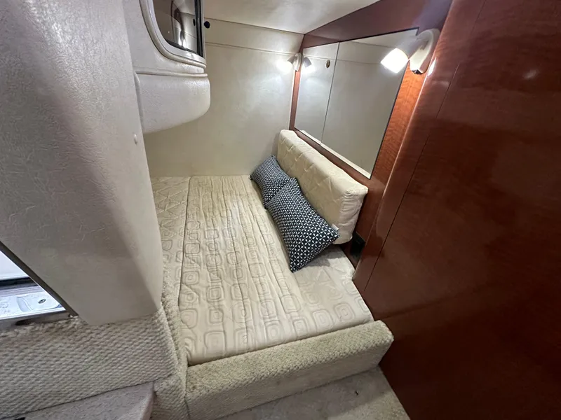 Slide: The Image of 2003 Sea Ray 280 Sundancer cabin interior with bed and pillows. - 16