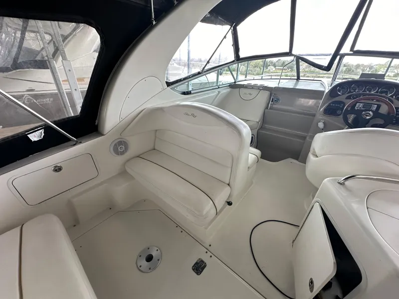 Slide: The Image of Interior of a 2003 Sea Ray 280 Sundancer boat with white seating and dashboard. - 8