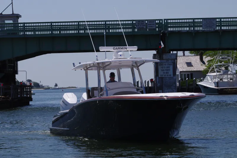 Slide: The Image of 2024 Mag Bay 33 CC boat cruising under a bridge on a sunny day. - 10