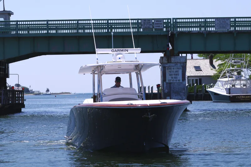 Slide: The Image of 2024 Mag Bay 33 CC boat passing under a bridge on a sunny day. - 11