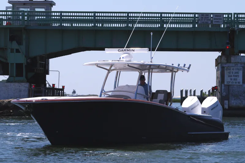 Slide: The Image of 2024 Mag Bay 33 CC boat cruising under a bridge. - 3