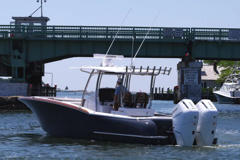 Slide: The Image of 2024 Mag Bay 33 CC boat cruising under a bridge. - 5