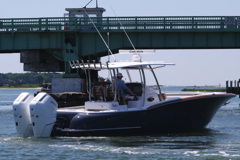 Slide: The Image of 2024 Mag Bay 33 CC boat cruising under a bridge. - 8