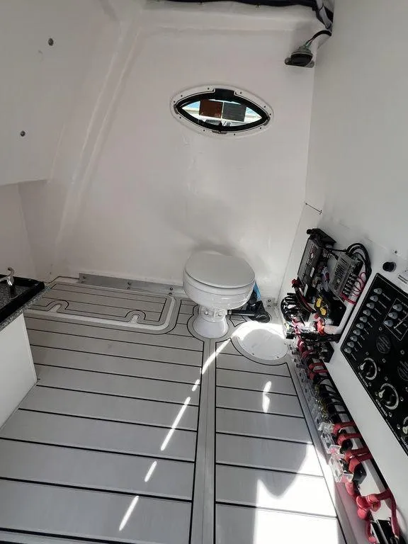 Slide: The Image of 2024 Twin Vee 400 Center Console GFX interior with toilet and control panel. - 35