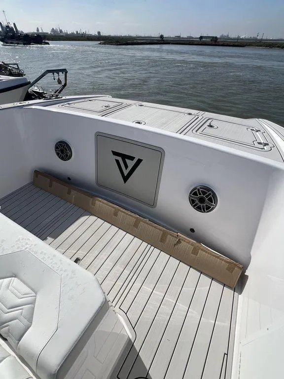 Slide: The Image of 2024 Twin Vee 400 Center Console GFX boat deck with logo, speakers, and seating. - 44