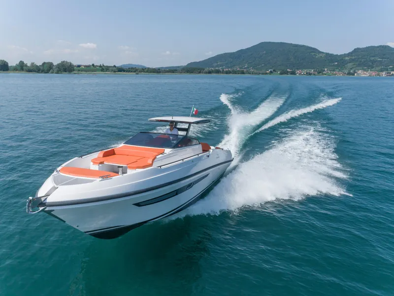 The Image of 2024 Rio Yachts Daytona 35 cruising on a serene lake with scenic mountain backdrop. - 0