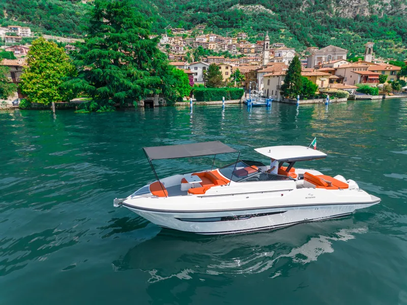 Slide: The Image of 2024 Rio Yachts Daytona 35 cruising on a scenic lake with vibrant surroundings. - 11