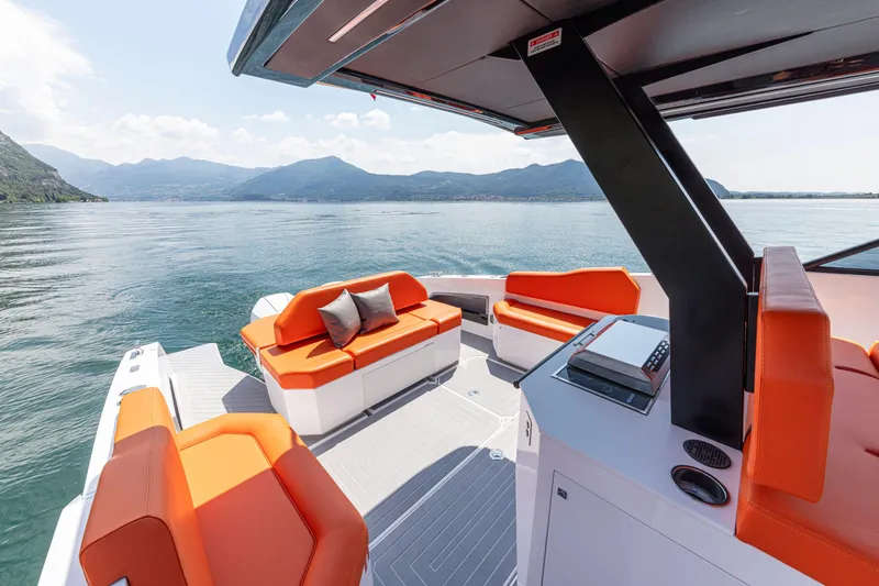 Slide: The Image of 2024 Rio Yachts Daytona 35 with orange seating, cruising on a serene lake. - 18