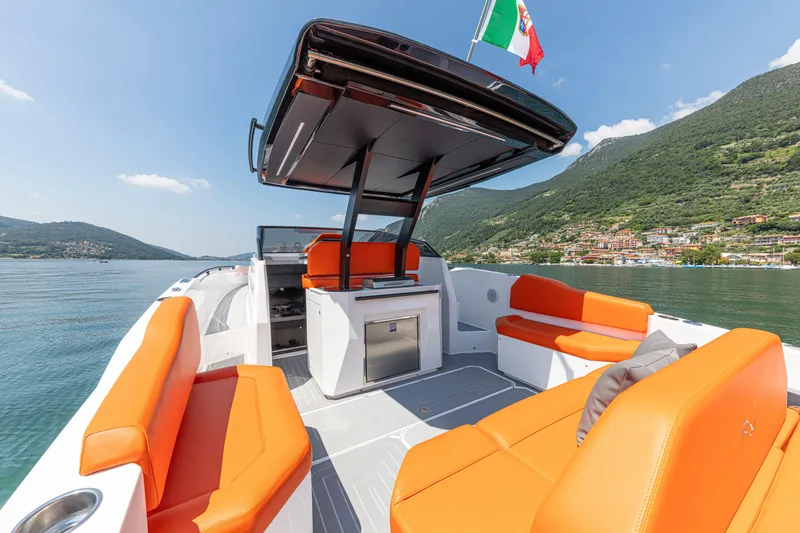 Slide: The Image of 2024 Rio Yachts Daytona 35 with vibrant orange seating on a serene lake. - 19