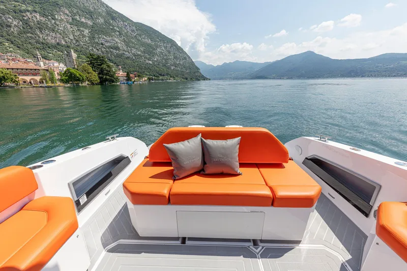 Slide: The Image of 2024 Rio Yachts Daytona 35 with orange seating, scenic lake and mountain backdrop. - 23