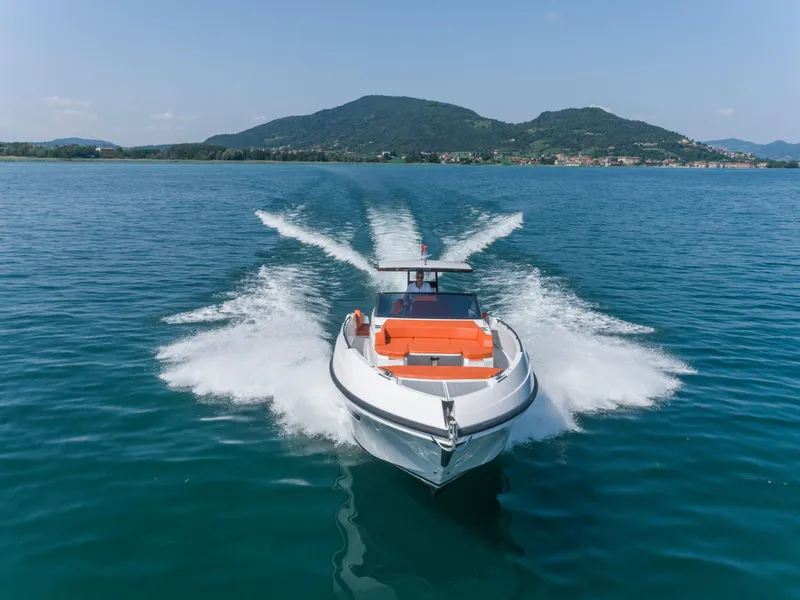 Slide: The Image of 2024 Rio Yachts Daytona 35 cruising on a serene lake with mountainous backdrop. - 3