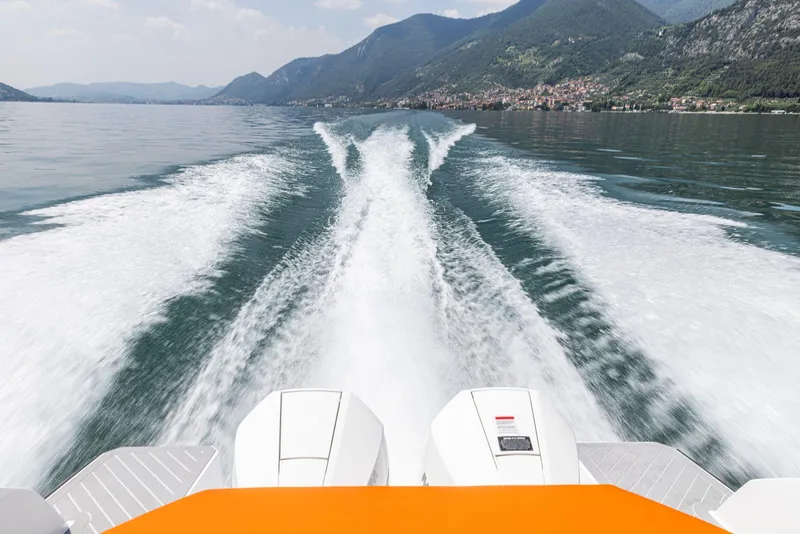 Slide: The Image of 2024 Rio Yachts Daytona 35 cruising on a scenic lake with mountainous backdrop. - 8