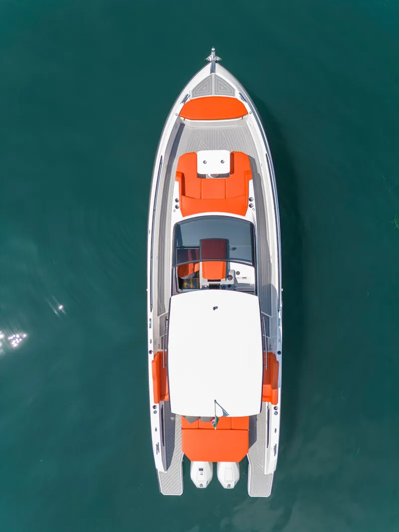 Slide: The Image of 2024 Rio Yachts Daytona 35, aerial view, sleek design, vibrant orange accents, cruising on clear water. - 9
