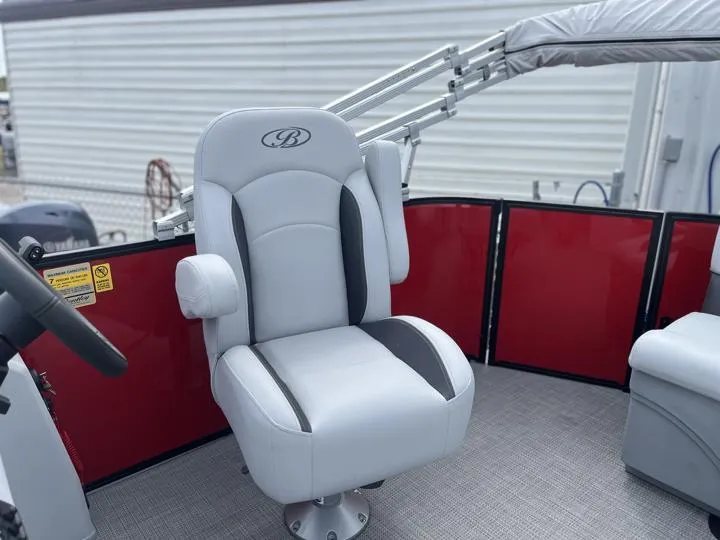 Slide: The Image of 2024 Bentley Pontoons LE 160 CR captain's chair with red paneling. - 12