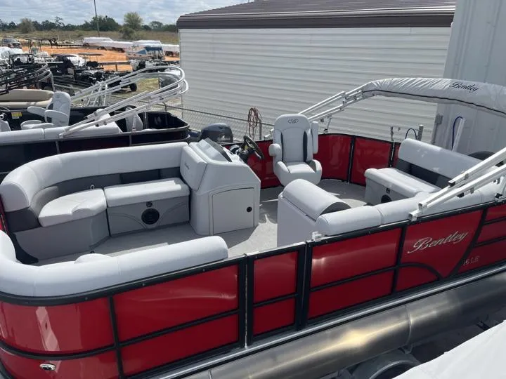 Slide: The Image of 2024 Bentley Pontoons LE 160 CR, red and gray interior, docked at a marina. - 3