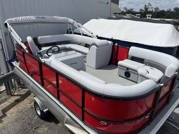 Slide: The Image of 2024 Bentley Pontoons LE 160 CR, red pontoon boat with white seating, docked outdoors. - 7