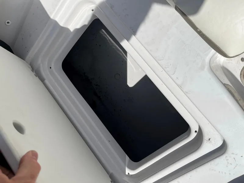 Slide: The Image of 2018 Glastron GTD storage compartment with open lid. - 12